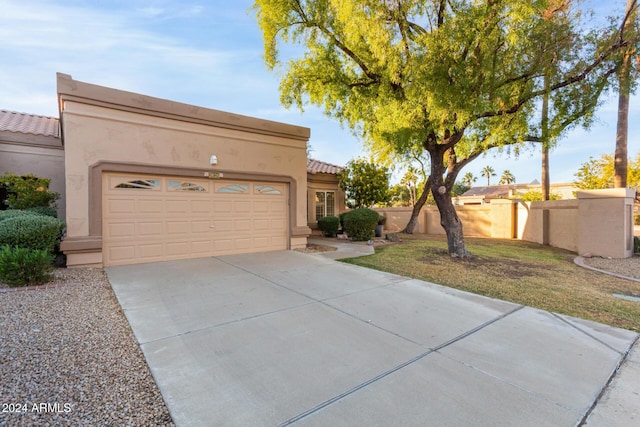 adobe home featuring a front yard and a garage