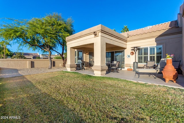 rear view of house with a yard and a patio