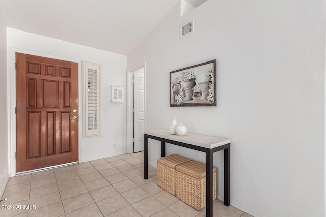 foyer with light tile patterned floors and vaulted ceiling