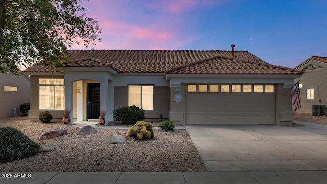 mediterranean / spanish house featuring central AC and a garage