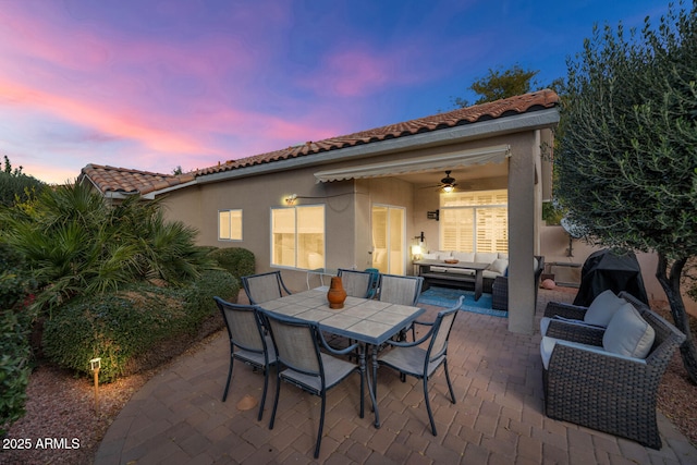 patio terrace at dusk with ceiling fan and an outdoor hangout area