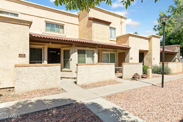 view of front facade with stucco siding and a fenced front yard