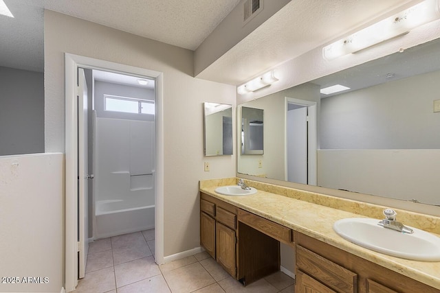 bathroom featuring a sink, visible vents, a textured ceiling, and tile patterned flooring
