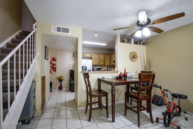 dining room with visible vents, a textured ceiling, a ceiling fan, and stairway