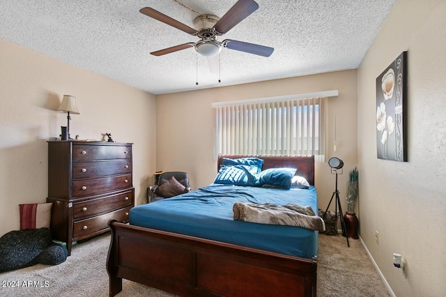 bedroom featuring baseboards, carpet floors, a textured ceiling, and a ceiling fan