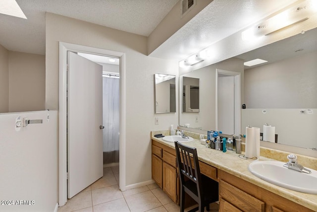 full bathroom featuring tile patterned flooring, visible vents, double vanity, and a sink