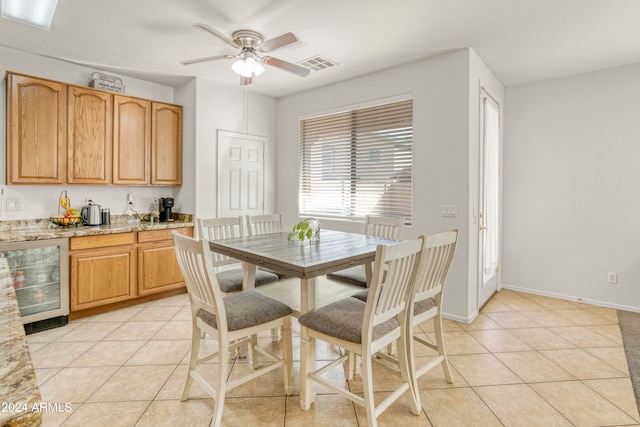 dining area featuring wine cooler, ceiling fan, and light tile patterned floors