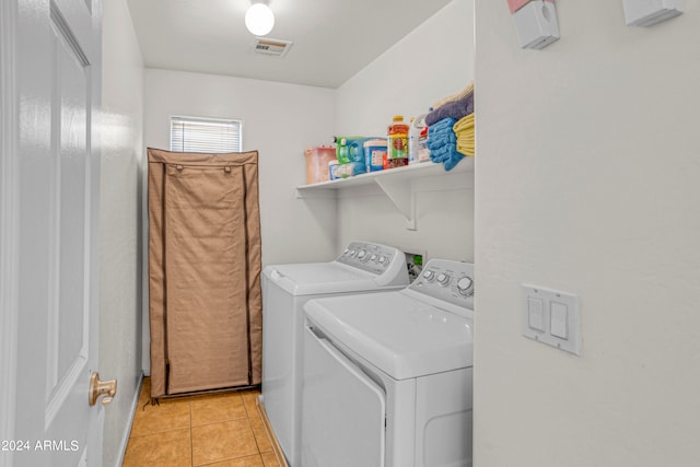 clothes washing area featuring light tile patterned flooring and separate washer and dryer