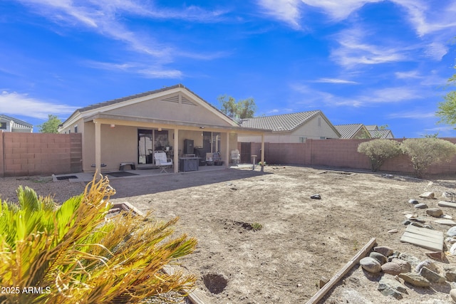 5769 E Good Pasture Ln, Florence, AZ 85132 - back of property with stucco siding, a patio area, and a fenced backyard