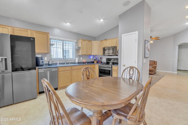 5769 E Good Pasture Ln, Florence, AZ 85132 - kitchen featuring appliances with stainless steel finishes, light brown cabinets, vaulted ceiling, arched walkways, and a ceiling fan