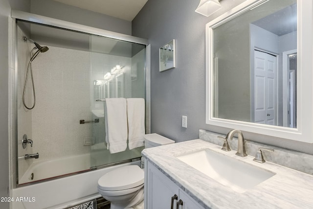 full bathroom featuring shower / bath combination with glass door, vanity, and toilet