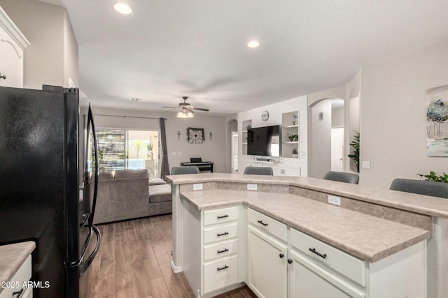 3719 E Sandy Way, Gilbert, AZ 85297 - kitchen featuring freestanding refrigerator, arched walkways, open floor plan, ceiling fan, and wood finished floors