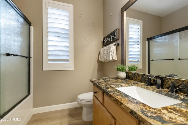 full bathroom with bath / shower combo with glass door, wood-type flooring, toilet, and vanity