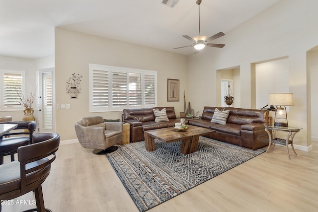 living room with ceiling fan, lofted ceiling, and light hardwood / wood-style floors