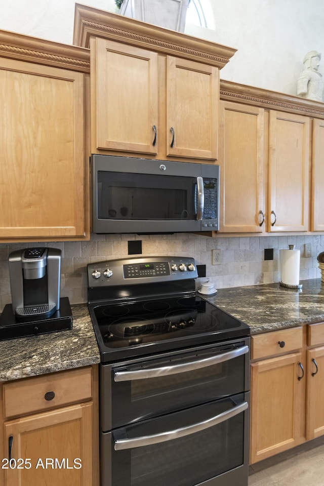 kitchen with double oven range, decorative backsplash, and dark stone counters