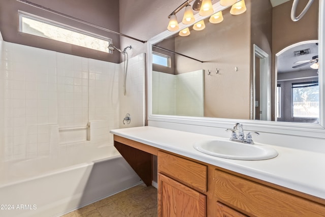 bathroom with ceiling fan, vanity, and tiled shower / bath combo