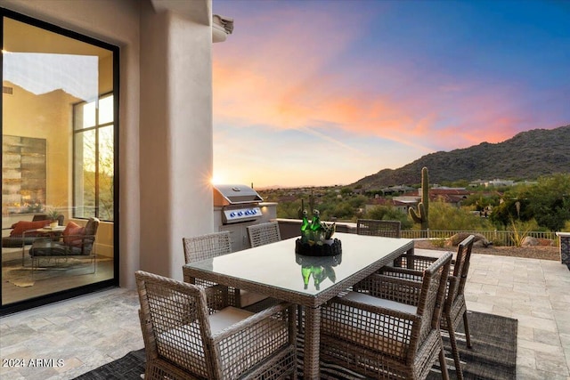 patio terrace at dusk with a grill and a mountain view