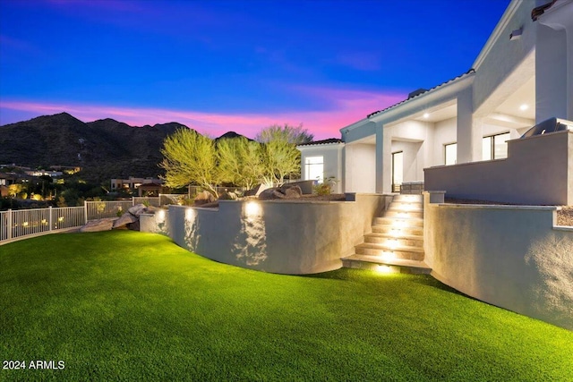 yard at dusk featuring a mountain view