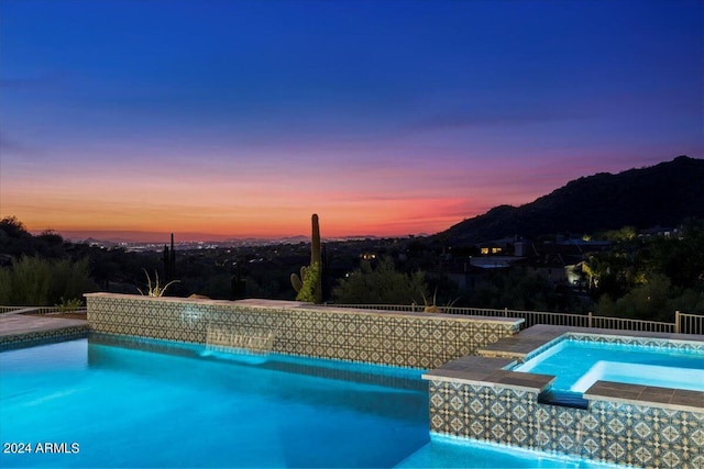 pool at dusk featuring a mountain view