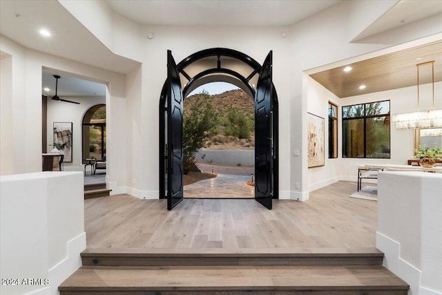 entrance foyer featuring light wood-type flooring and ceiling fan with notable chandelier