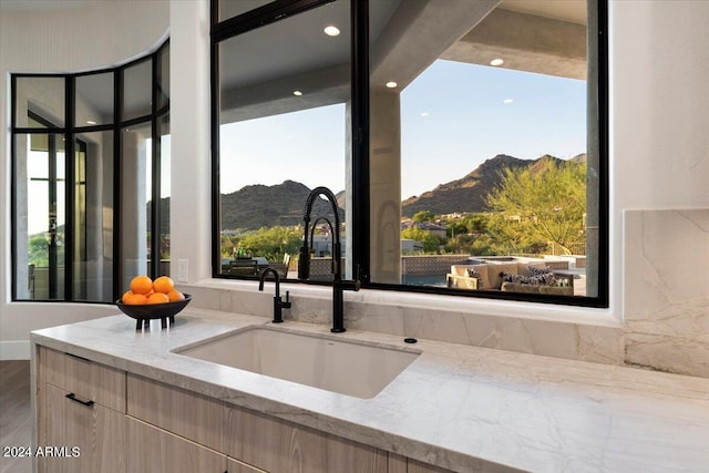 interior space with a mountain view, a wealth of natural light, and light stone counters