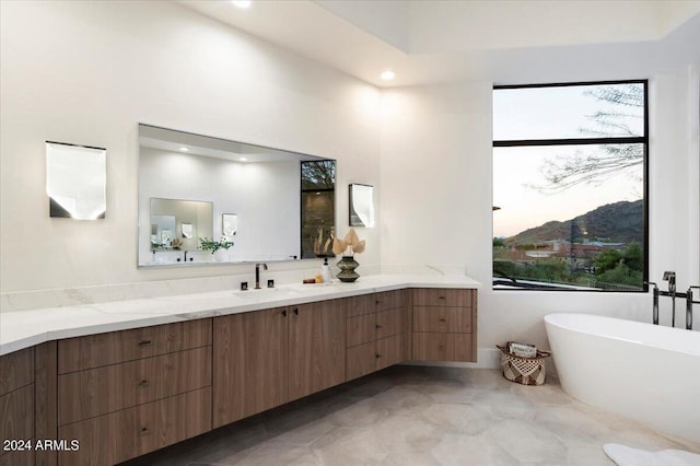 bathroom featuring a mountain view, vanity, and a bathtub