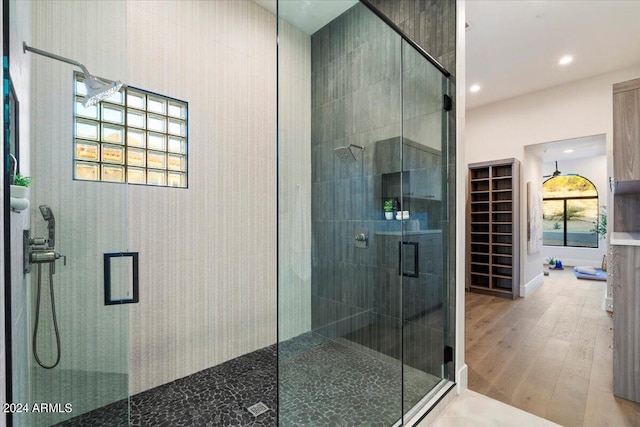 bathroom with walk in shower and wood-type flooring