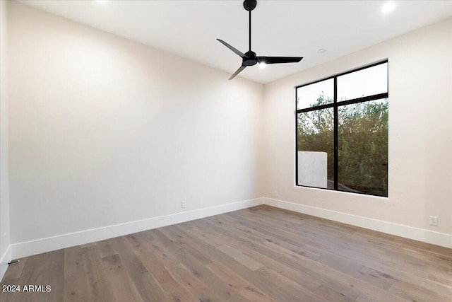 empty room with ceiling fan and light hardwood / wood-style floors