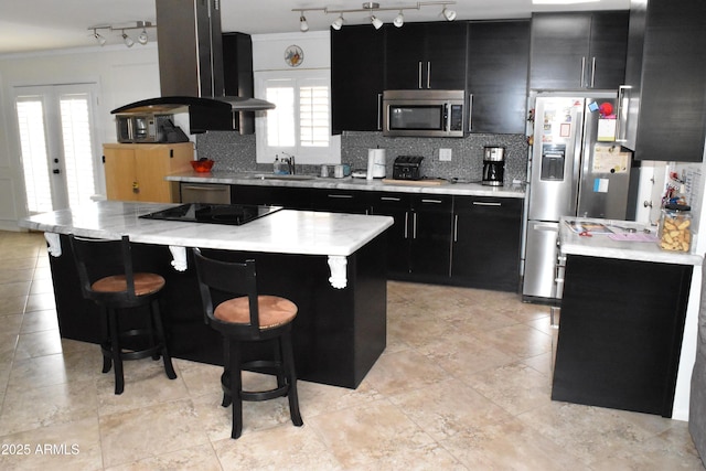 kitchen with light countertops, backsplash, appliances with stainless steel finishes, a sink, and dark cabinetry