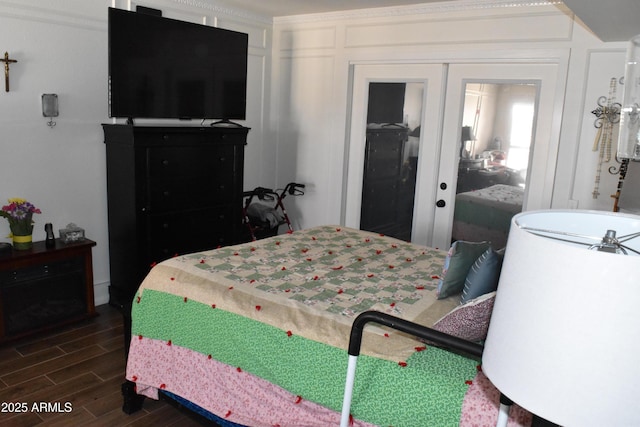 bedroom featuring a decorative wall, french doors, a closet, and wood tiled floor