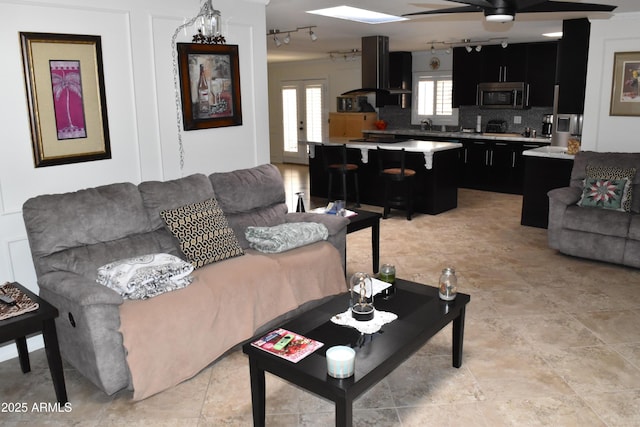 living room featuring ceiling fan and french doors