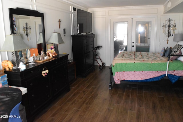 bedroom featuring a decorative wall, dark wood-style flooring, and french doors