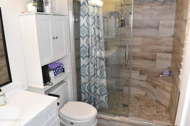 bathroom with toilet, a stall shower, and vanity