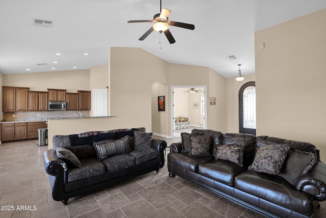 living room with ceiling fan and high vaulted ceiling