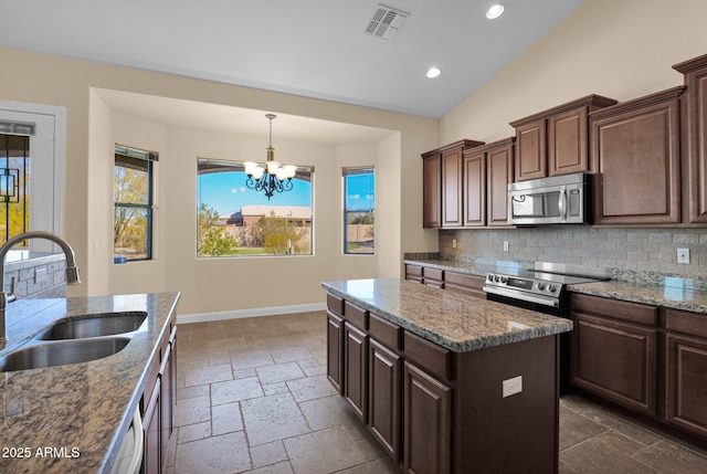 kitchen featuring stainless steel appliances, a center island, a notable chandelier, dark brown cabinetry, and sink