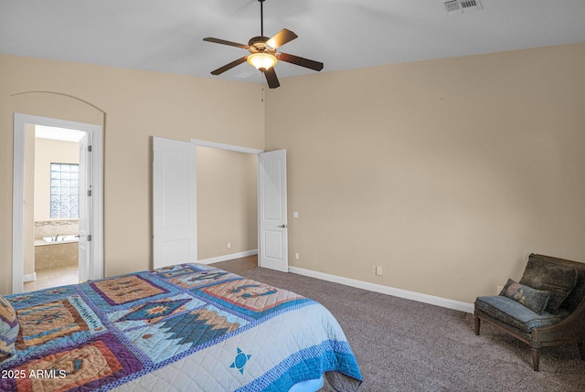 carpeted bedroom with ensuite bath and ceiling fan