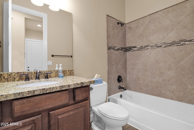 full bathroom with toilet, tiled shower / bath, and vanity