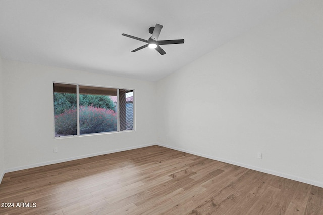 empty room with lofted ceiling, ceiling fan, and light wood-type flooring