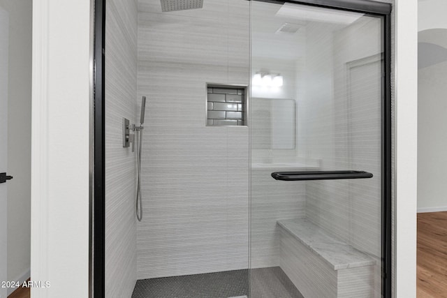 bathroom with wood-type flooring and a shower with door