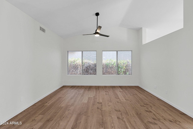 empty room with ceiling fan, high vaulted ceiling, and light hardwood / wood-style floors