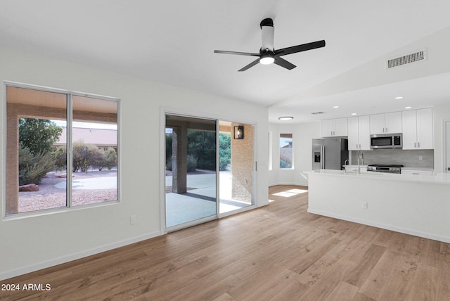 unfurnished living room featuring ceiling fan, vaulted ceiling, and light wood-type flooring