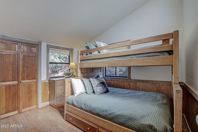 bedroom featuring vaulted ceiling and light wood-style flooring