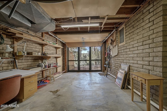 misc room featuring brick wall and concrete floors