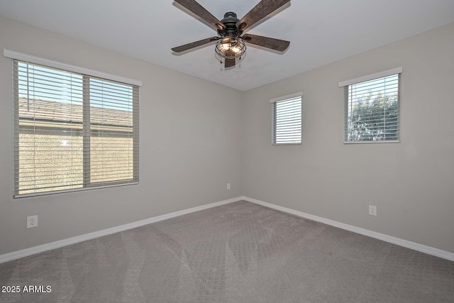 carpeted empty room with ceiling fan and baseboards