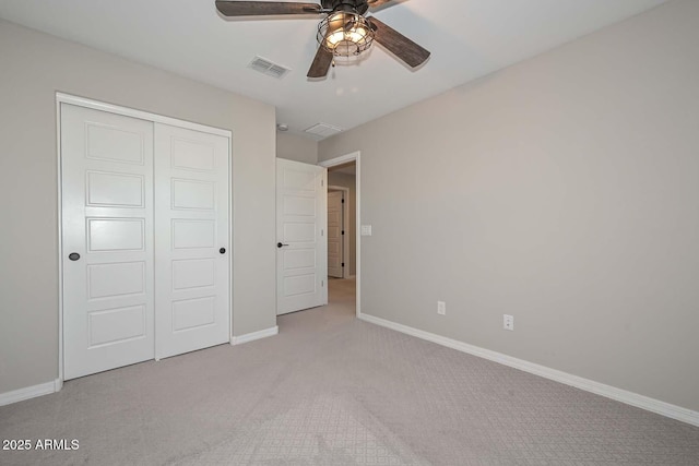 unfurnished bedroom featuring carpet, a closet, visible vents, a ceiling fan, and baseboards