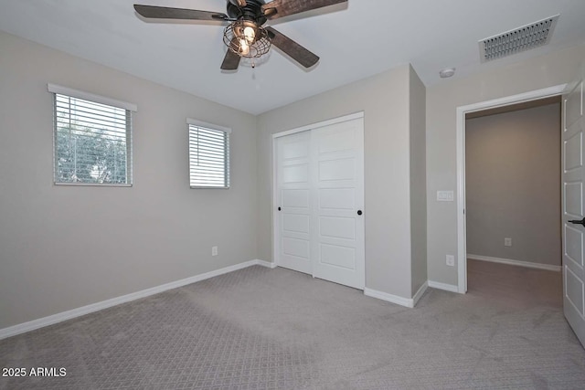 unfurnished bedroom featuring a closet, carpet, visible vents, and baseboards