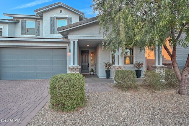 view of front of house with decorative driveway and stucco siding