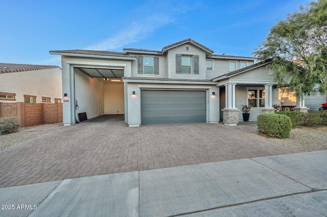 view of front of property with fence, decorative driveway, and stucco siding