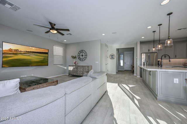 living area featuring recessed lighting, visible vents, and baseboards