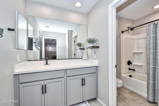 full bathroom featuring visible vents, toilet, wood finished floors, shower / bathtub combination with curtain, and vanity